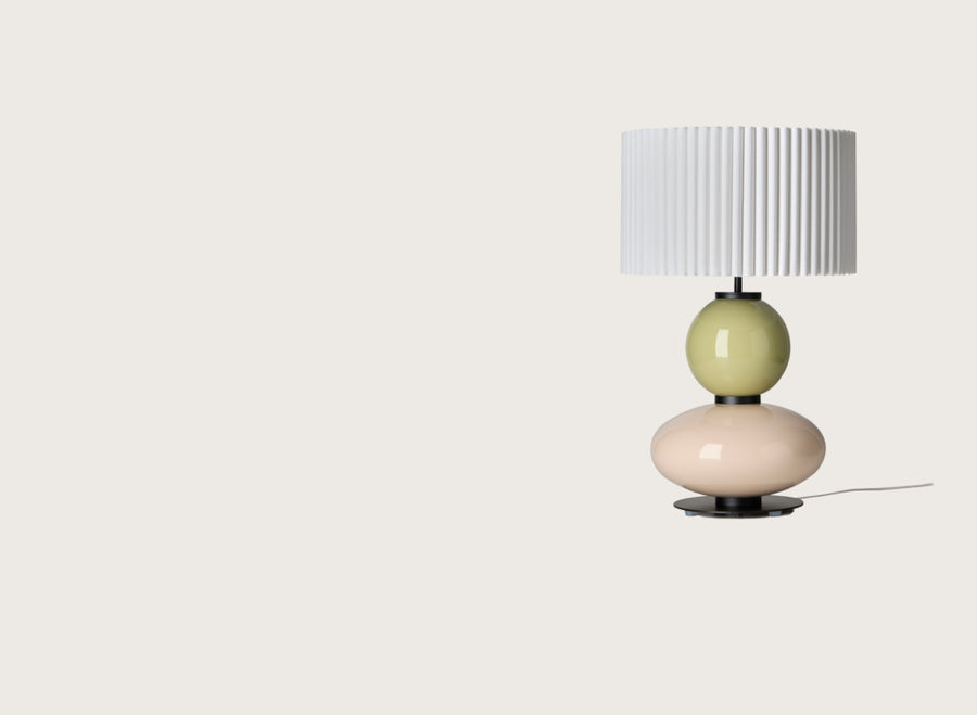 Modern table lamp with a yellow and white glass base and a pleated shade from Aromas. Available at Spacio retails stores in India. 
