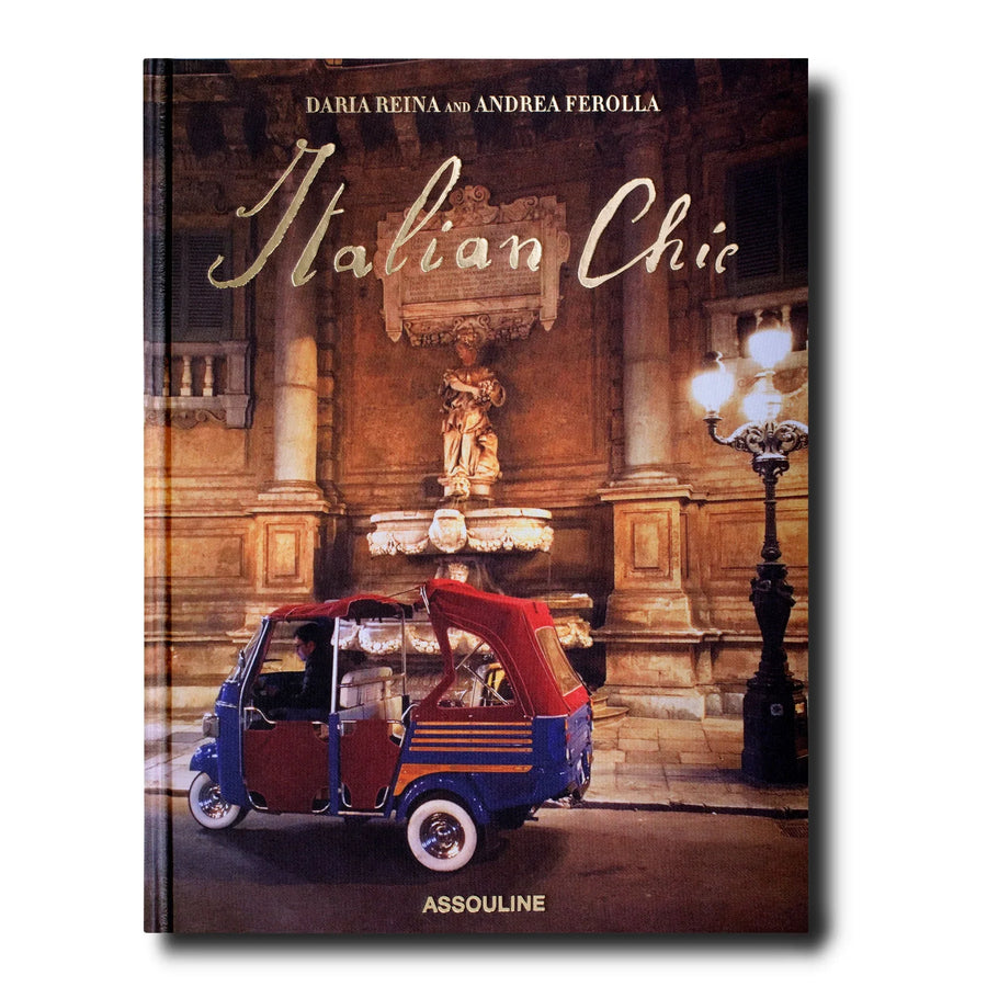 An Assouline Coffee Table Book Italian Chic that exudes beauty and style showcasing a red car in front of a charming fountain.