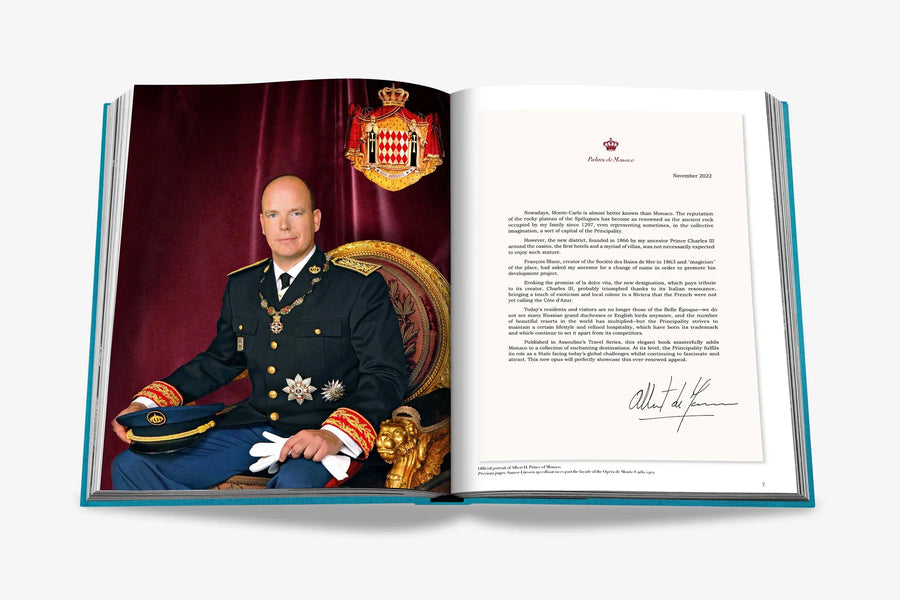 An elegant royal portrait with a letter beside him on a double spread of a luxurious hardbound Assouline's Monte Carlo coffee table book, featuring a vibrant cover with images of Monaco's iconic landmarks, available at Spacio India.