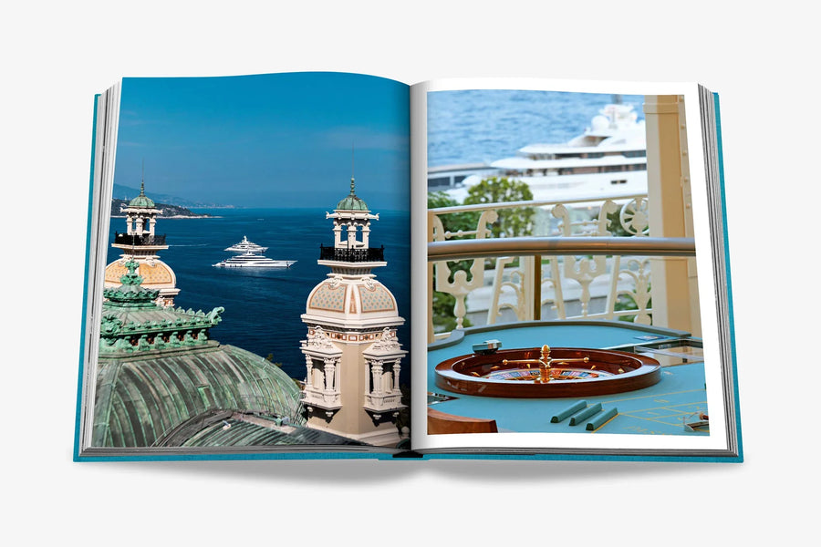Stunning views of Monaco’s historic architecture, luxury yachts, and a classic casino roulette table on a double spread page of a luxurious Assouline's Monte Carlo coffee table book, featuring a vibrant cover with images of Monaco's iconic landmarks, available at Spacio India.
