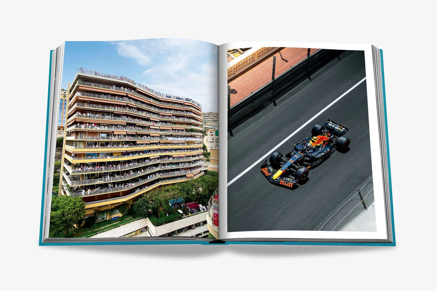 A double spread of the thrill of a left packed luxury apartment building with spectators watching the race, and on the right, a high-speed Red Bull Formula 1 car on the famous Monte Carlo street circuit in a luxurious Assouline's Monte Carlo coffee table book, featuring a vibrant cover with images of Monaco's iconic landmarks, available at Spacio India.