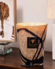 Luxury Baobab Stones Lazuli Candle burning on a wooden console, adding warmth and a refined scent of cardamom and musk