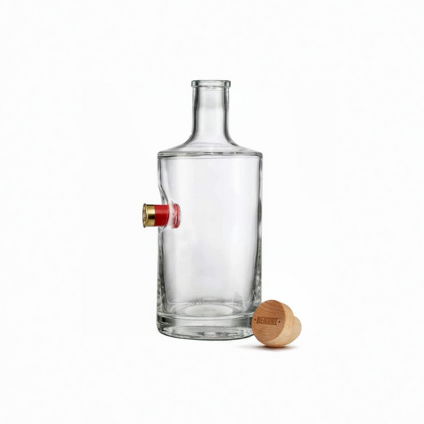 Clear glass decanter with a unique design, featuring an empty shotgun shell, on a white background from the American brand Benshot available at Spacio retail stores in Mumbai & Kolkata. 