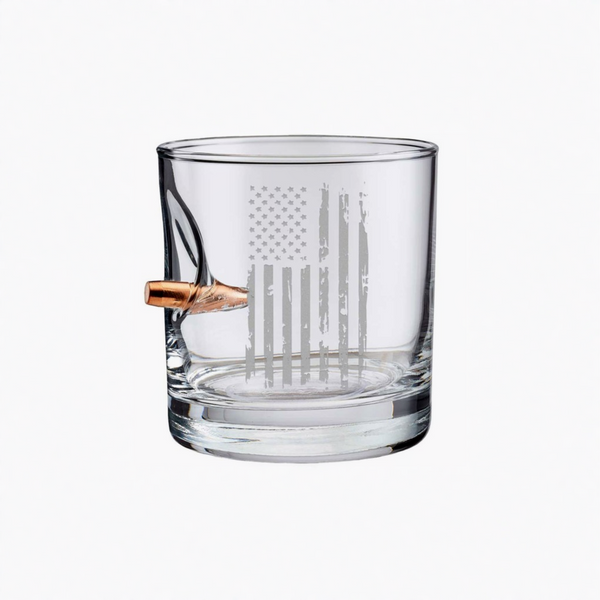Clear whiskey glass with American flag engraving and bullet on a white background from the American brand Benshot available at Spacio retail stores in Mumbai & Kolkata. 