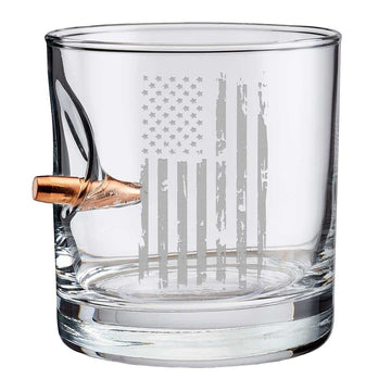 Clear whiskey glass with American flag engraving and bullet on a white background from the American brand Benshot available at Spacio retail stores in Mumbai & Kolkata. 