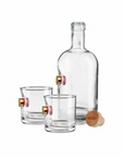 Clear whiskey decanter and two glasses with shotgun shell on a white background from the American brand Benshot available at Spacio retail stores in Mumbai & Kolkata. 
