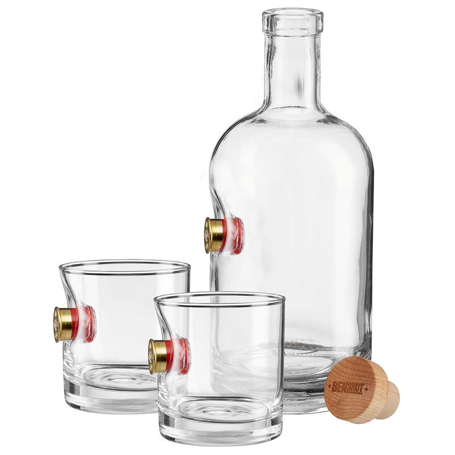 Clear whiskey decanter and two glasses with shotgun shell on a white background from the American brand Benshot available at Spacio retail stores in Mumbai & Kolkata. 