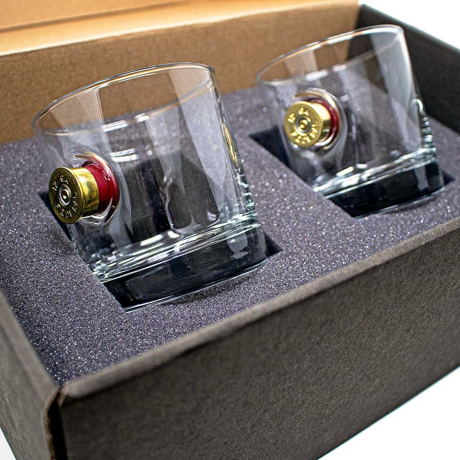 Two whiskey glasses with bullet in a box