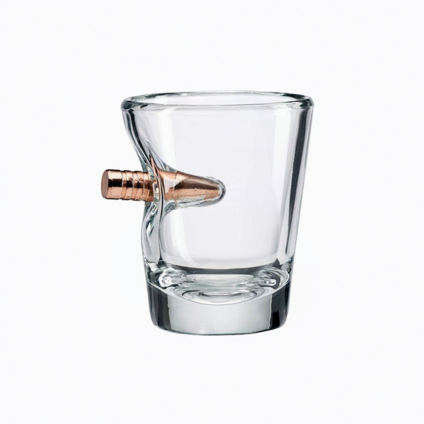 Clear glass shot glass with a bronze bullet on a white background from the American brand Benshot available at Spacio retail stores in Mumbai & Kolkata.