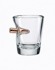 Clear glass shot glass with a bronze bullet on a white background from the American brand Benshot available at Spacio retail stores in Mumbai & Kolkata.