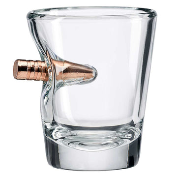 Clear glass shot glass with a bronze bullet on a white background from the American brand Benshot available at Spacio retail stores in Mumbai & Kolkata.