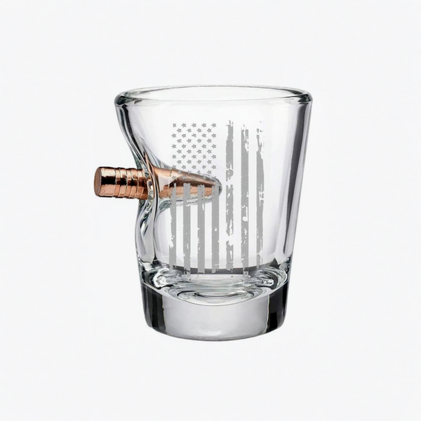 Clear glass shot glass with a bullet-shaped handle on a white background from the American brand Benshot available at Spacio retail stores in Mumbai & Kolkata. 