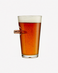 Pint glass filled with beer on a white background in a glass with bullet