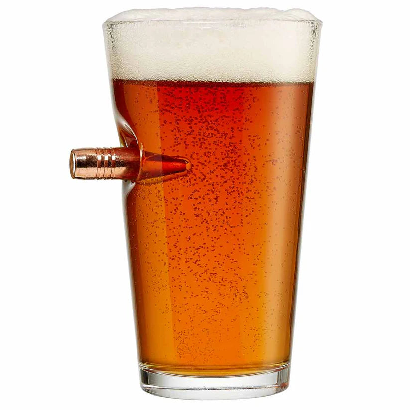 Pint glass filled with beer on a white background in a glass with bullet