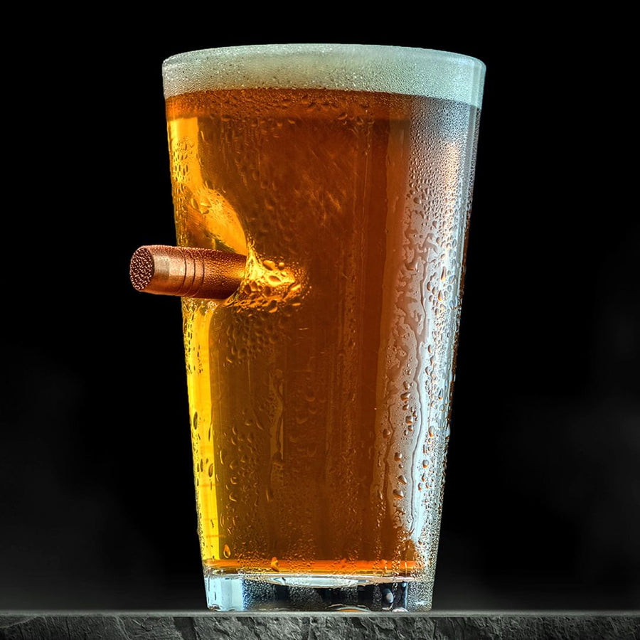 Pint Glass of beer with a bullet on a black background