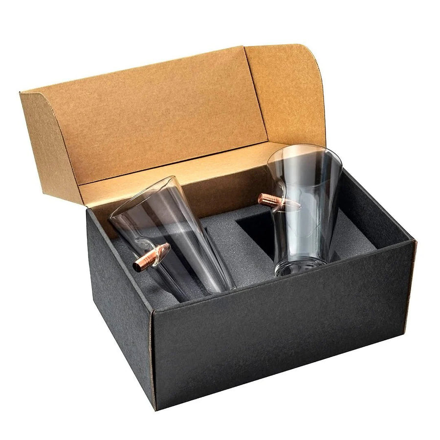 Two clear beer pint glass tumblers with bullets in a black box with a brown lid.