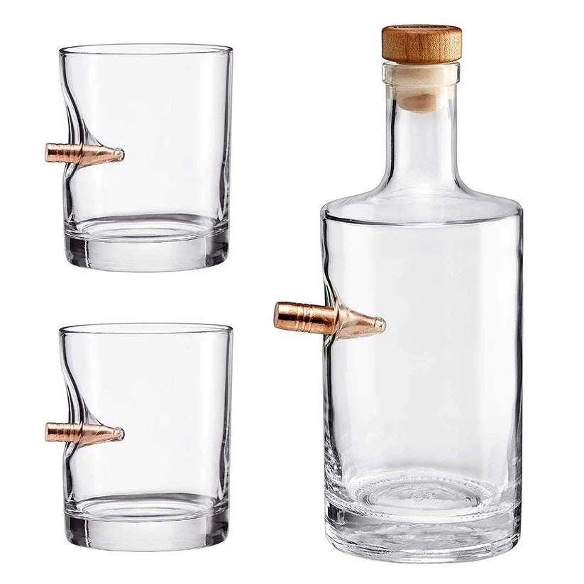 Clear glass whiskey decanter and two glasses with bullet on a white background from American brand Benshot available at Spacio retail stores in Mumbai & Kolkata. 