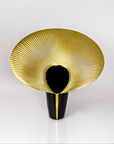 Decorative vase with gold and black design on a white background