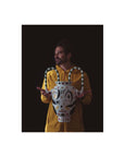Person holding a decorative vase with a black background