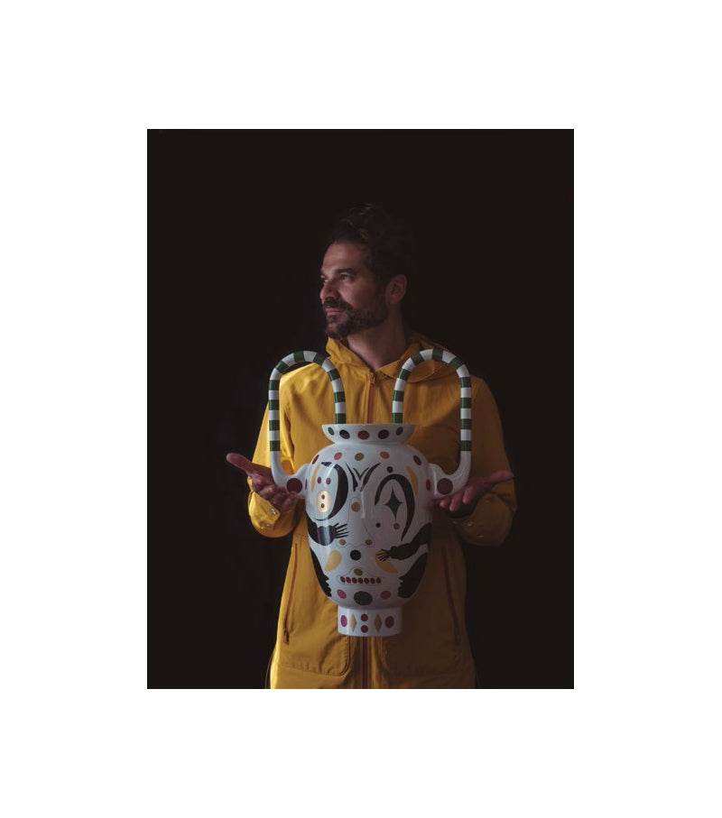 Person holding a decorative vase with a black background