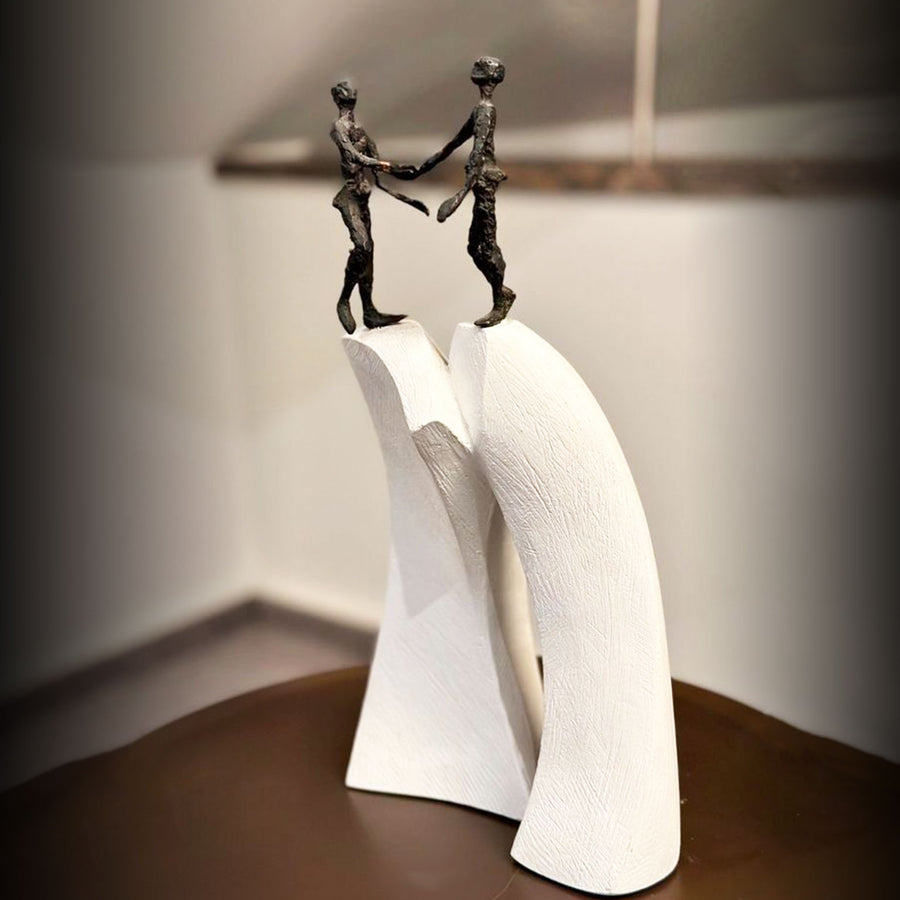 A Butzon Bercker sculpture of two people holding hands in a unified gesture.