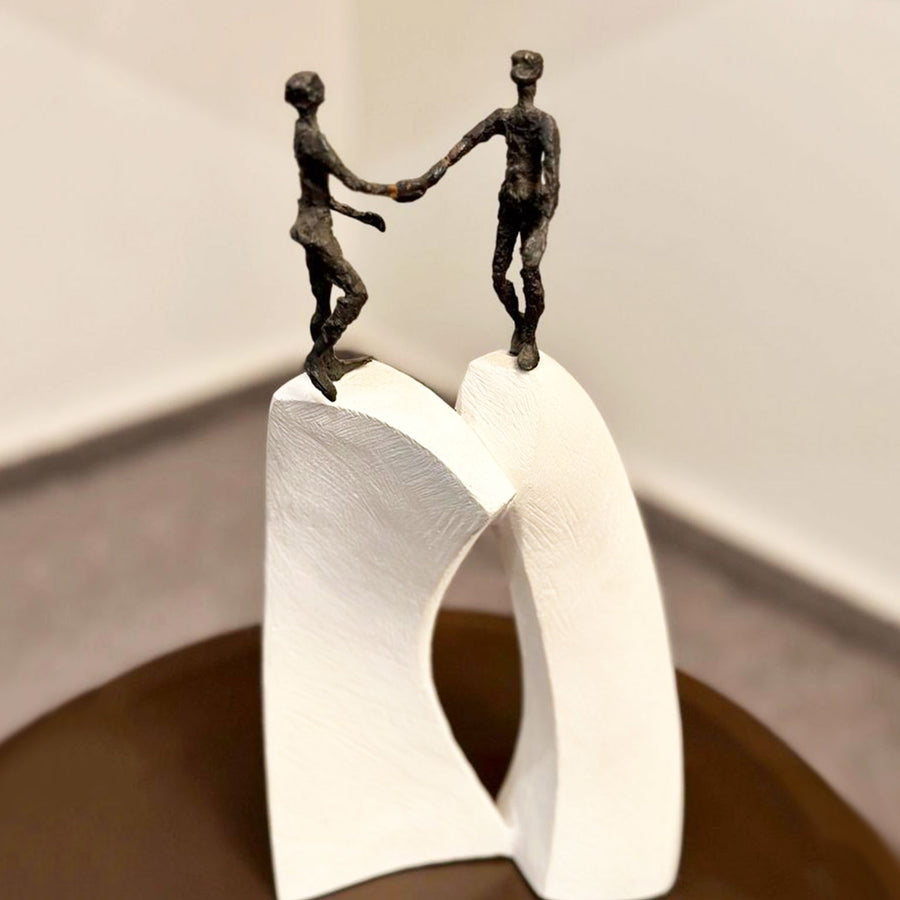 A Butzon Bercker sculpture depicting two people standing on top of a pedestal, symbolizing unity.