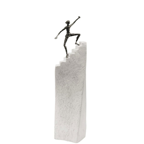A Butzon Bercker sculpture of a motivated man on top of a stair, symbolizing success.