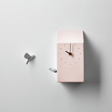 A pink Haoshi cuckoo clock adorned with a bird.