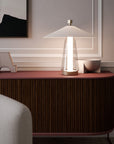 Modern table lamp on a wooden sideboard with abstract art in the background