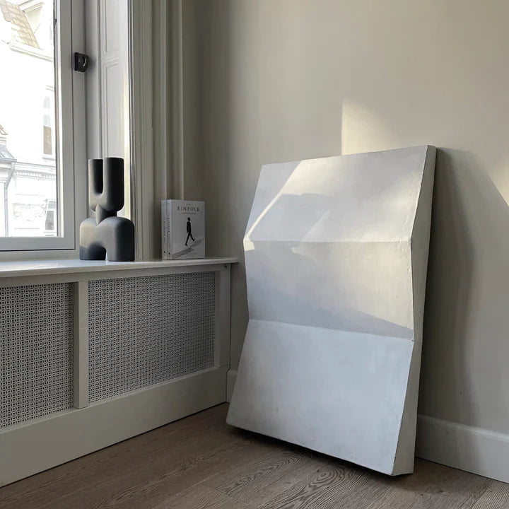 A black piece of furniture in front of a window with the 101Cph Cobra Double Medio Black 212006 vase by 101 Copenhagen.