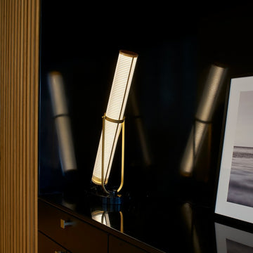 La Lampe Frechin table lamp by DCW Editions on a dark wooden sideboard