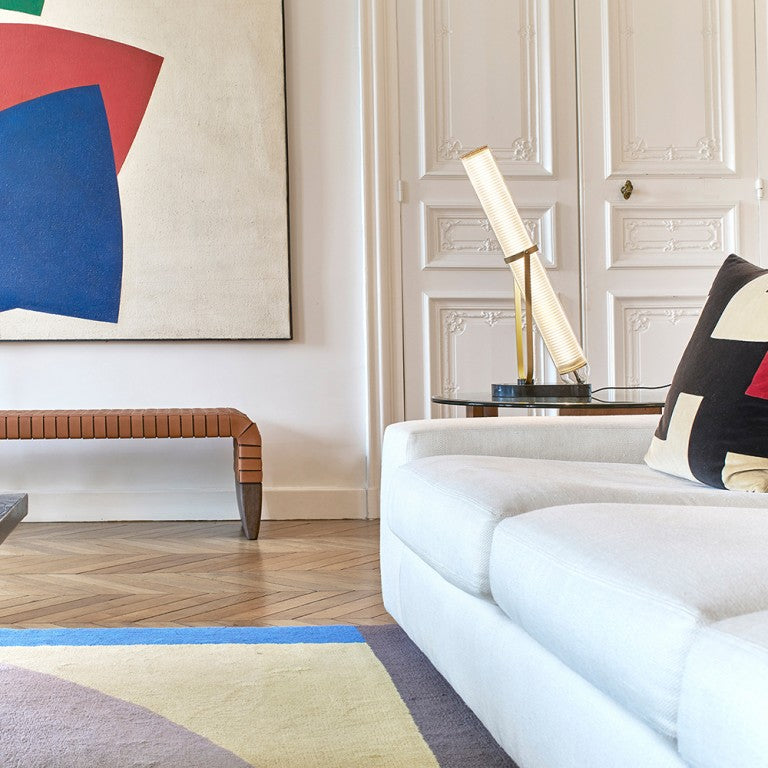 La Lampe Frechin table lamp by DCW Editions on a side table in a modern luxury living room. 