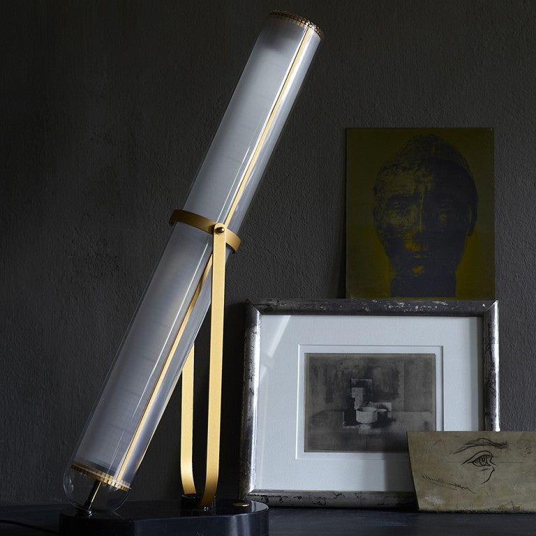 La Lampe Frechin table lamp by DCW Editions  with brass detailing styled on a table next to a photo frame. 