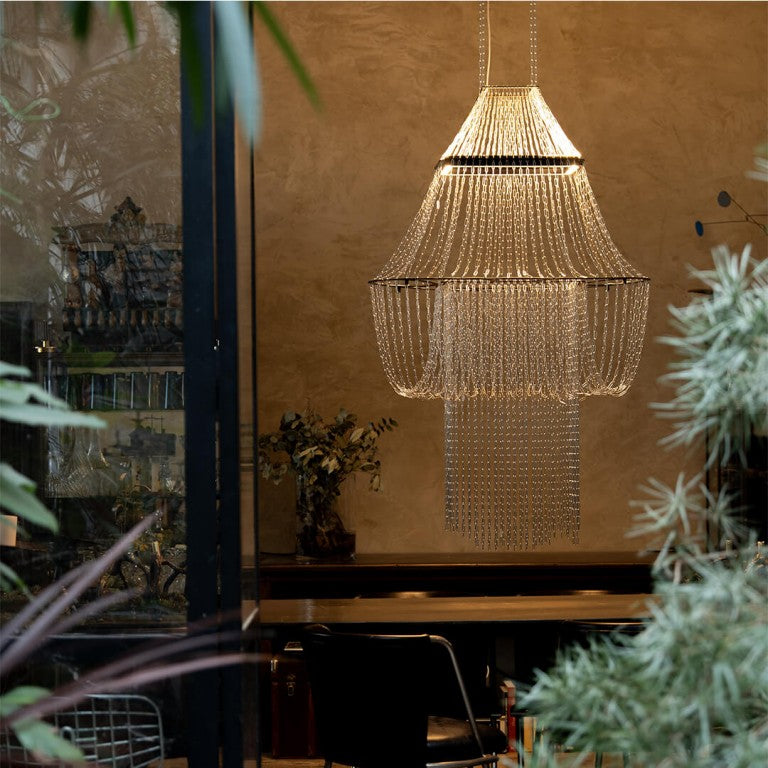 A lit up chandelier in front of a beige wall from DCW editions in modern style interiors