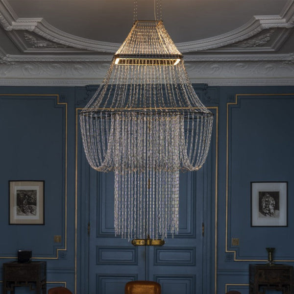 Chandelier hanging in a room with blue walls and decorative molding.