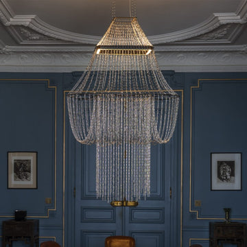 Chandelier hanging in a room with blue walls and decorative molding.