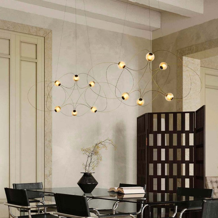 Modern chandelier hanging above a dining table in a stylish room.