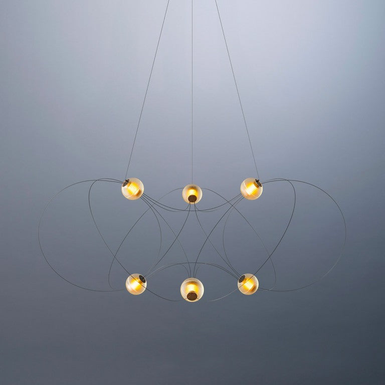 Modern chandelier with six hanging lights on a gray background from DCW Editions