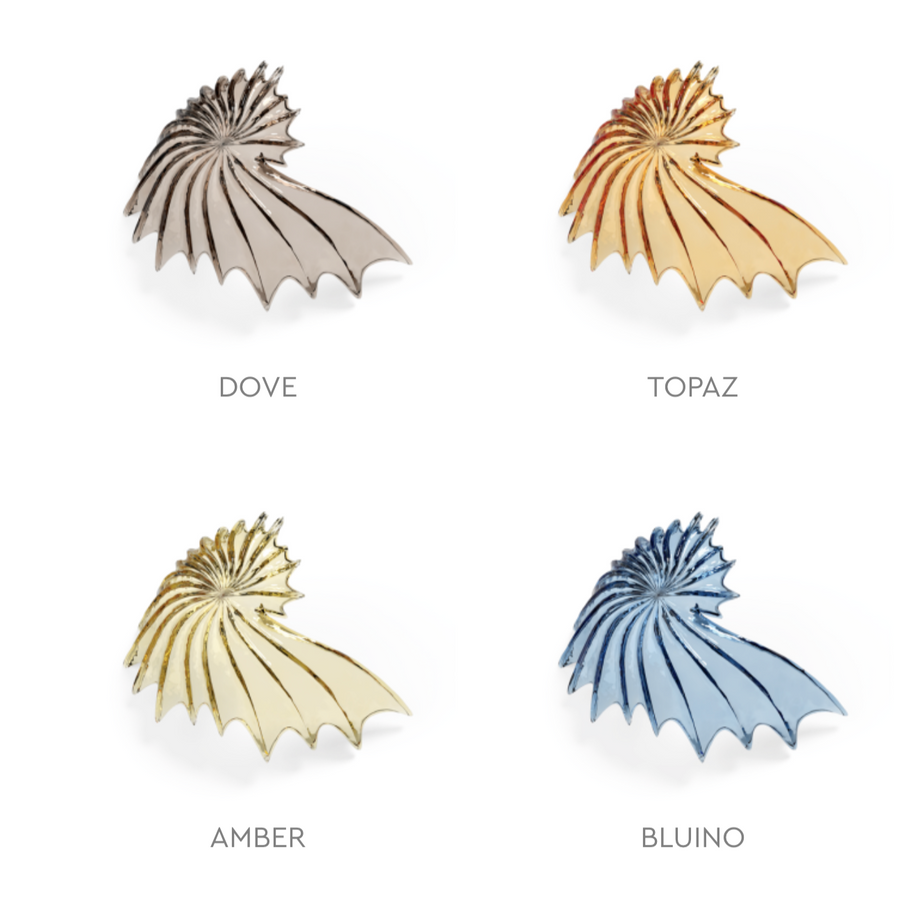 Four shell-shaped glass elements from Italamp's Kaleido collection in different finishes on a white background