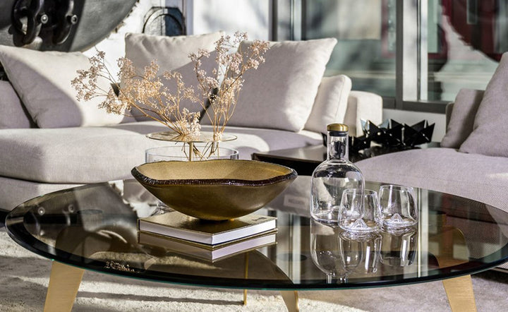 Spacio offers Decor Accessories from best international Brands for luxury home decor. Gardeco Mapa Green Bowl with a book, drink ware & decorative baby breath plant on a round coffee table in a luxury home interior living room.