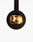 A modern black round wood burning firewood stove with a visible fire burning inside, shown against a plain white background.