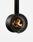 A modern black circular wood-burning fireplace with a visible flame and logs inside, shown against a plain light gray background.