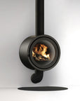 A modern black circular wood-burning stove with a visible fire inside, shown against a clean white background with a black floor shadow.