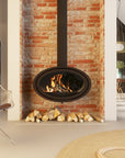 Modern wood burning fireplace with burning logs against a brick wall in a living room setting.