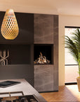 A modern teardrop-shaped woven pendant light hangs in a contemporary kitchen or living space with a dark wood cabinet, built-in gas fireplace, stone tile panels, a potted palm, and a light wood floor.