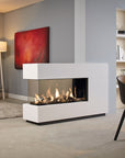 A modern white linear gas fireplace with a glass front and visible flames, placed in a contemporary living room with gray walls, a red abstract painting, a floor lamp, and a chair.
