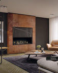A modern living room interior featuring a large copper-toned fireplace wall with a black gas firebox, a tan leather armchair, a round wooden coffee table, a gray rug, and a light gray sofa in a styled home environment.