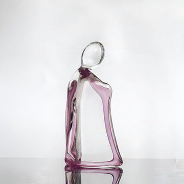 Glass sculpture of a woman with a purple tint on a white background titled HER from Duccio Di Segna, available at Spacio retail stores in Mumbai & Kolkata. 