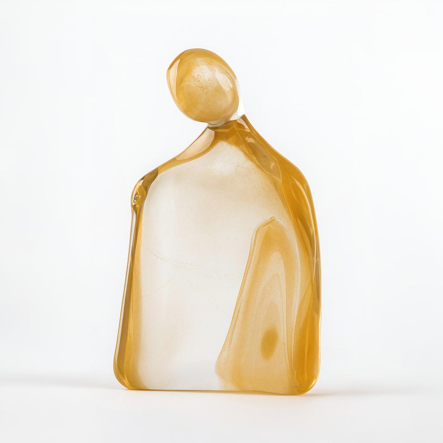 Glass sculpture of a woman with 24K gold dust on a white background