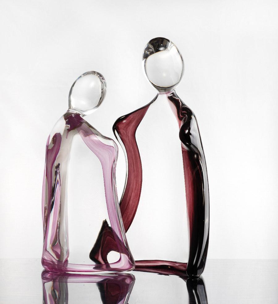 Artistic glass sculpture of two abstract figures titled Him & Her from Duccio Di Segna on a white background available at Spacio retail stores in Mumbai & Kolkata. 